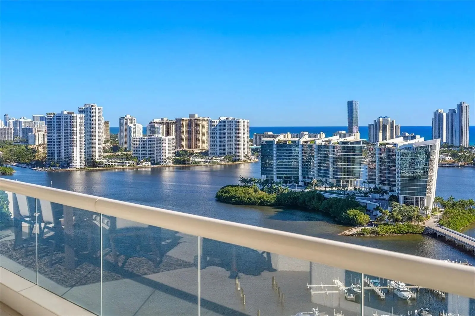 Balcony view across the waterway to waterfront towers, with the ocean on the horizon